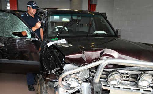 HUNT FOR DRIVER: Scenes of Crime officer Senior Constable Malcolm Clark from Kingaroy dusts a stolen Land Cruiser for prints yesterday. The Land Cruiser, stolen from Rockhampton, crashed into a Gympie police car in Clematis Street Tuesday night. HUNT FOR DRIVER: Scenes of Crime officer Senior Constable Malcolm Clark from Kingaroy dusts a stolen Land Cruiser for prints yesterday. The Land Cruiser, stolen from Rockhampton, crashed into a Gympie police car in Clematis Street Tuesday night.